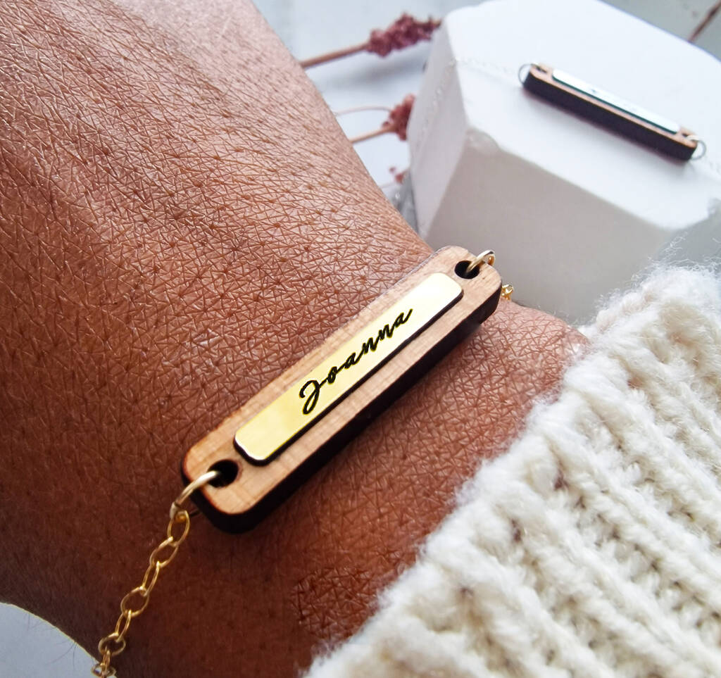 gold and wooden bracelet, personalised with a name pictured on a wrist